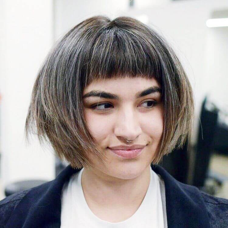 Short edgy bob haircut with bangs that frames the face