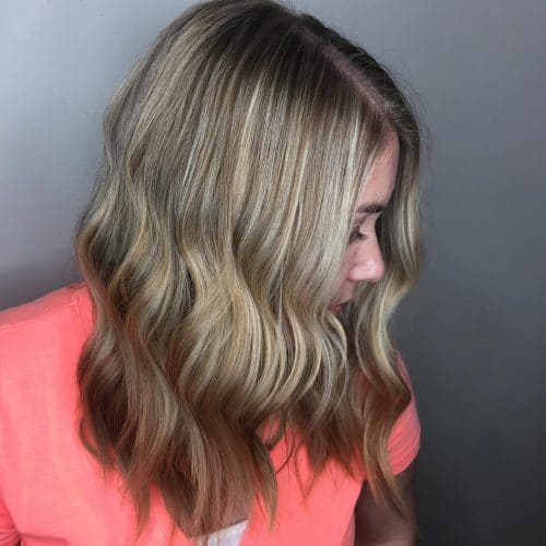 An attractive mid shoulder-length cut with beachy waves and bronde hair color
