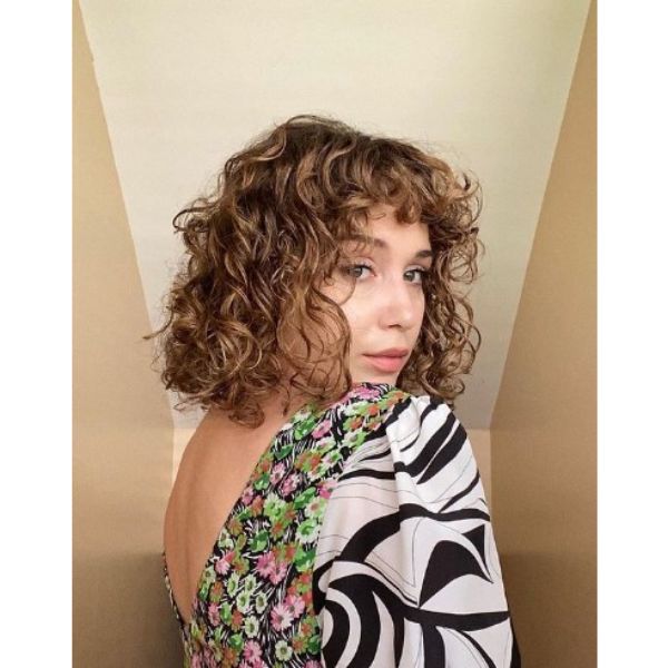 Curly Shaggy Bob With Tiny Bangs And Blonde Highlights
