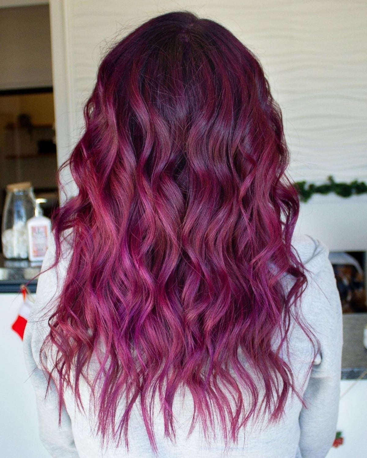 Dark magenta color melt on long curly hair