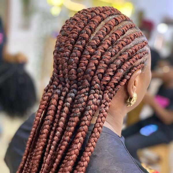 Ghana Braids - a woman wearing a gold earrings