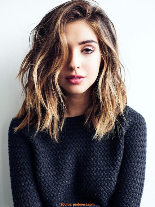 shoulder-length deep side part hairstyle and golden brown hair color