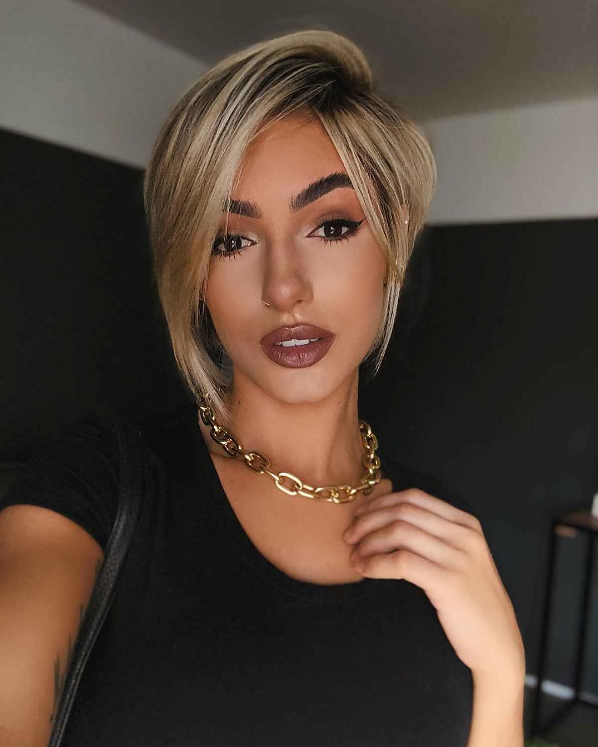 sleek asymmetrical bob with dark roots