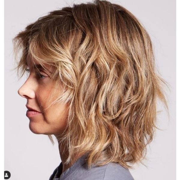 Warm Blonde Medium Haircut For Wavy Hair With Side-swept Strands