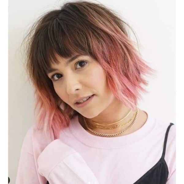 Wavy Medium Haircut With Peach Pink Highlights And Straight Bangs