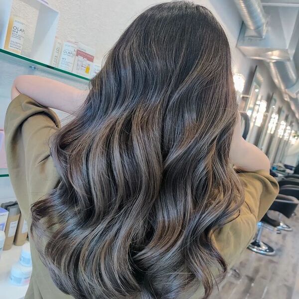 a woman in a salon wearing a brown shirt