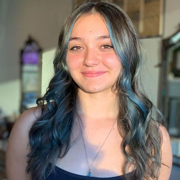 a woman wearing a black sleevless shirt has a icy blue highlights