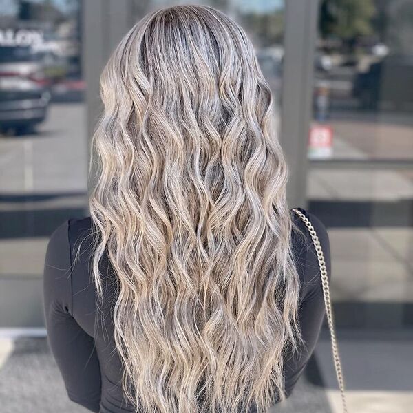 Beach Wave Platinum Blonde Balayage - a woman wearing a black fitted long sleeve