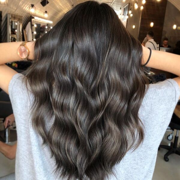 Beautiful Brunette Balayage on Dark Hair - a woman wearing gray top.