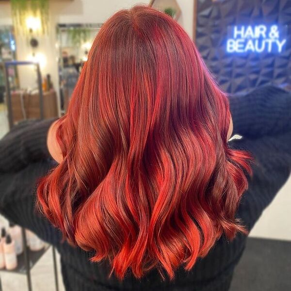 Bloody Red with Brown Balayage - a woman wearing knitted black long sleeves.