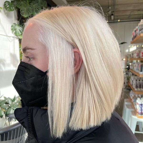 Bob Hair with Platinum Blonde - a woman wearing a thick jacket and a facemask