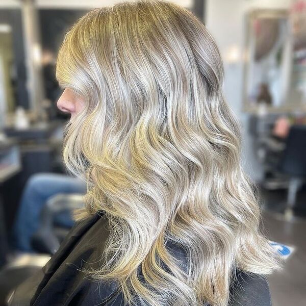 Bolton Ash Blonde Balayage - a woman wearing a black cape and is sitting in a salon chair