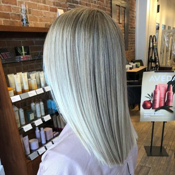 Bright Platinum Blonde - a woman in a salon facing a rack of salon supplies