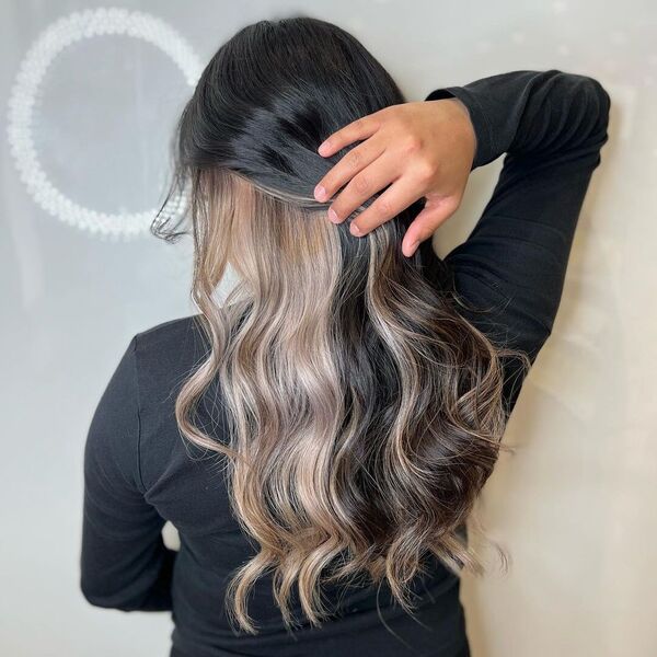 brown peekaboo hair - a girl touching her hair wearing black long sleeve