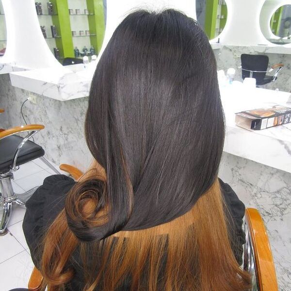 brown peekaboo hair - a woman seating on the barber's chair