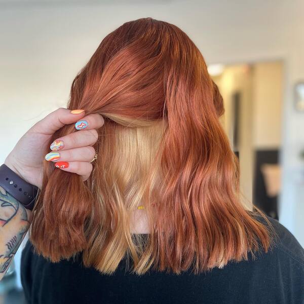 brown peekaboo hair - a woman wearing black shirt with someone holding her hair