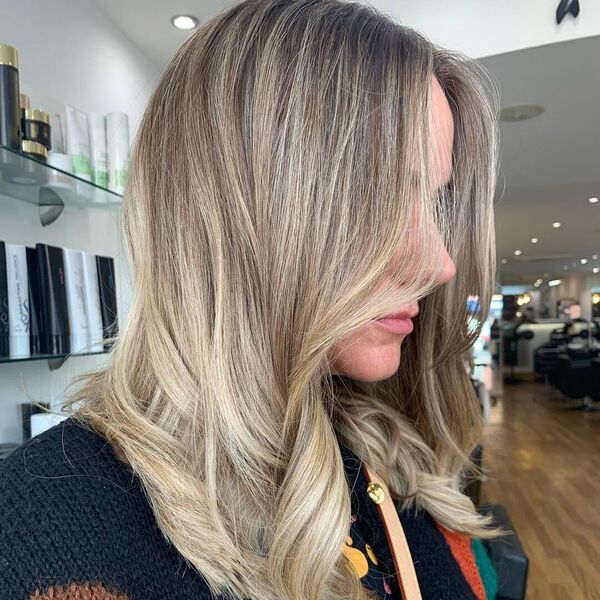 Creamy Ash Blonde Hair - a woman wearing a crochet sweater