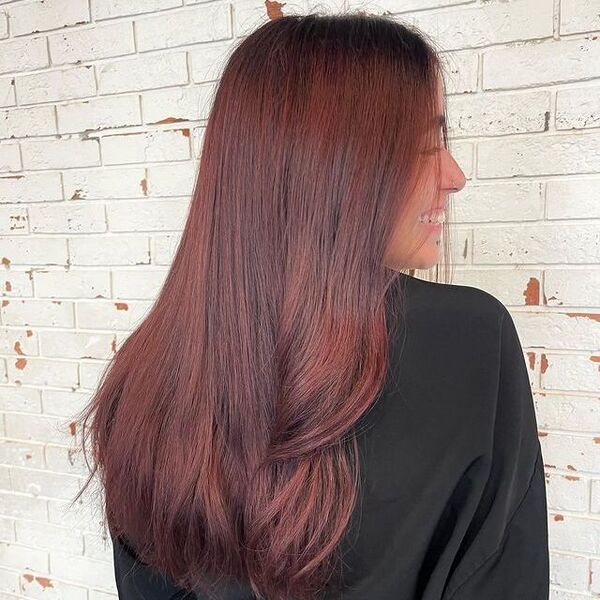 dark red hair - a girl smiling wearing a black barber's cape