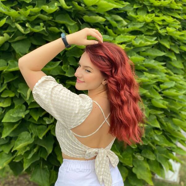 dark red hair - a girl wearing a backless dress with a watch on her wrist