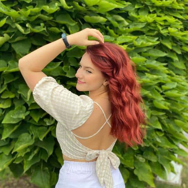 dark red hair - a girl wearing a backless dress with a watch on her wrist