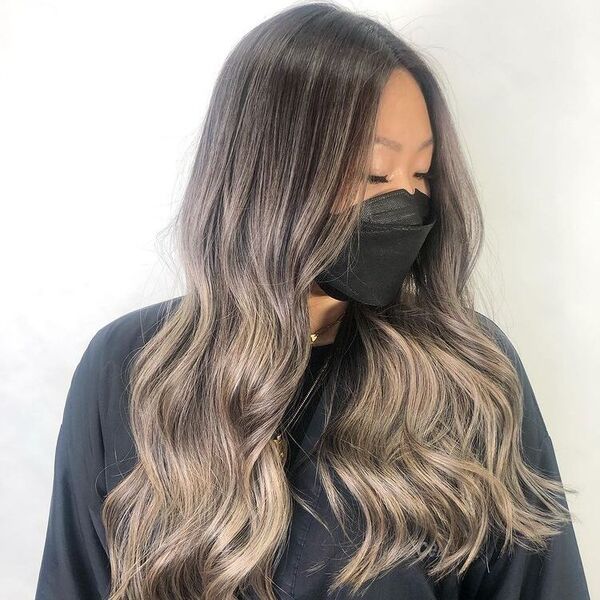 Dark Roots and Ash Light Brown Hair - a woman wearing a black facemask and a black cape