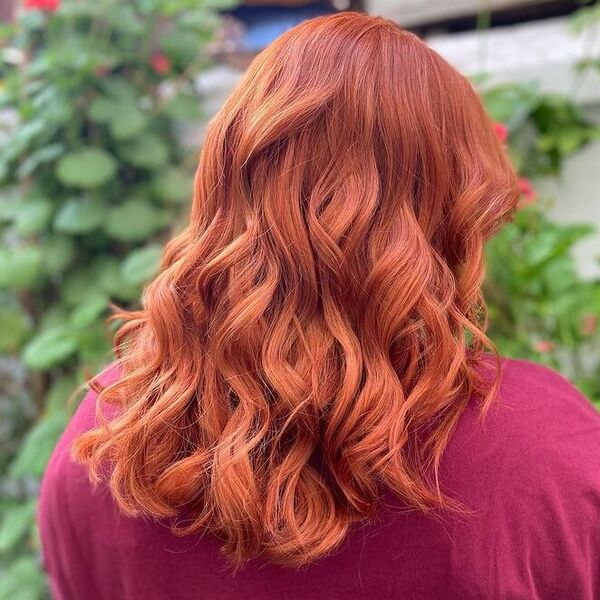 Ginger Brown Red Tight Curls - a woman wearing pink shirt.