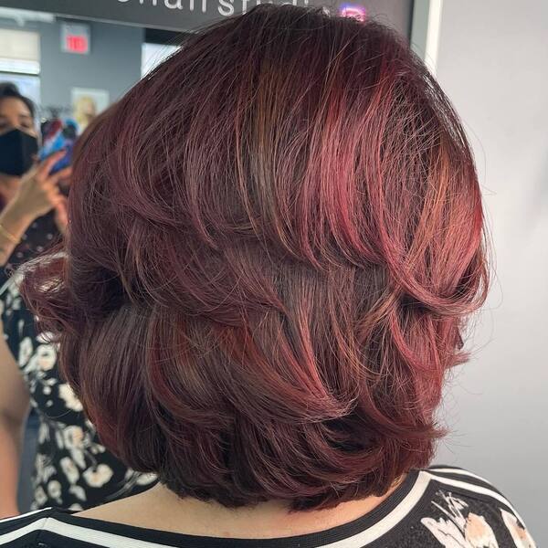 Layered Bob in Red Brown Balayage with Deep Roots - a woman wearing stripe floral top.