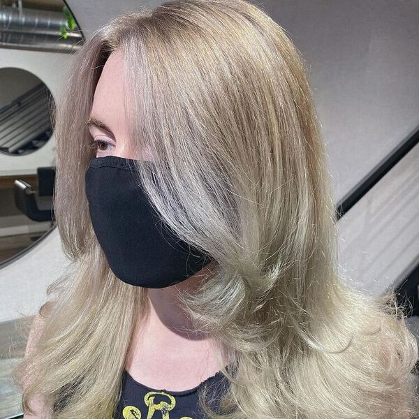 Layered Cut platinum Blonde - a woman wearing a sleeveless shirt and a black facemask