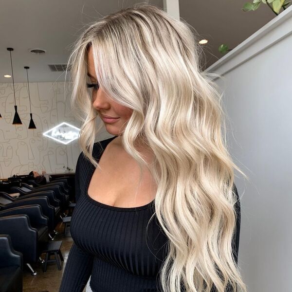 Long and Wavy Platinum Blonde Hair - a woman in a salon wearing a fitted long sleeve top