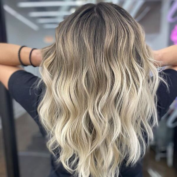 Long Layers Blonde Balayage - a woman wearing bracelets and a black shirt