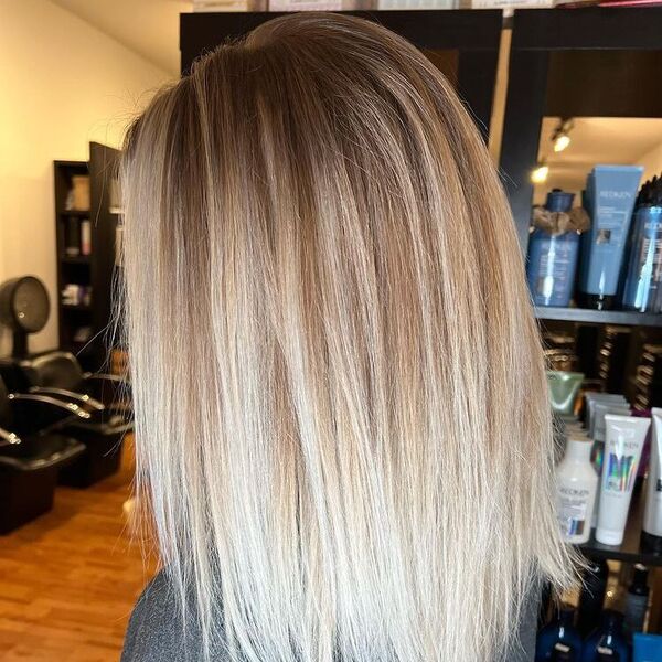 Painted Hottie Blonde Balayage - a woman standing and beside her are salon supplies