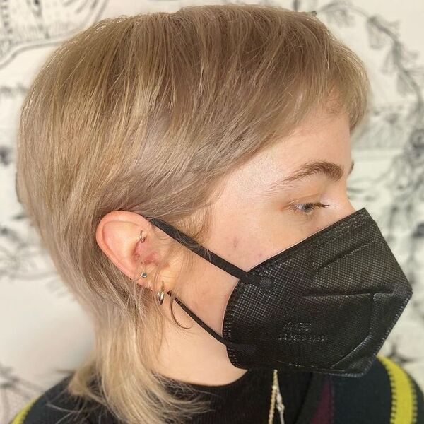 Perfect Sandy Ash Blonde - a woman wearing a black mask