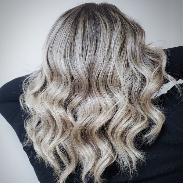 Platinum Blonde Balayage - a woman wearing a black long sleeve shirt