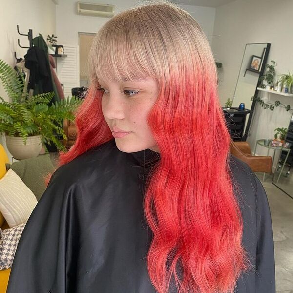 Red Brown Blond with Blunt Bangs - a woman wearing black salon cape.