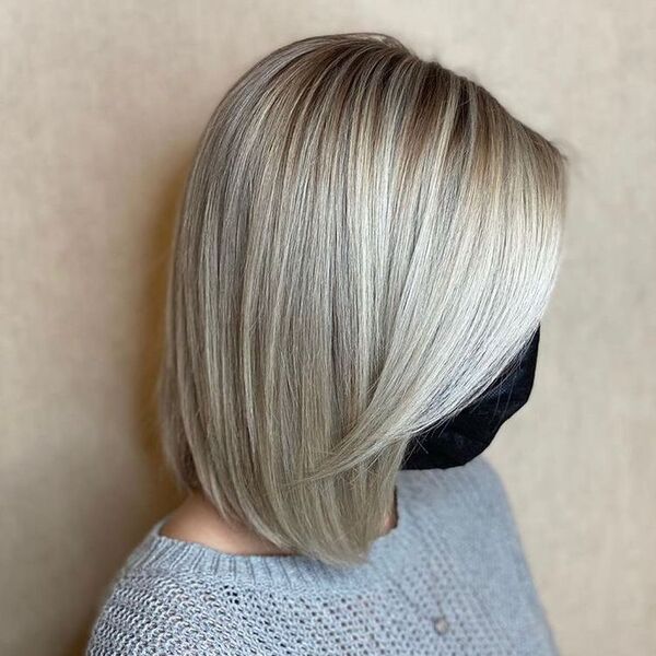 Seamless Blend Platinum Blonde - a woman wearing a gray knitted blouse and a mask