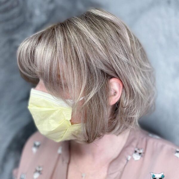 Short Bob with Brighter Ash Blonde - a woman wearing an old rose blouse and a yellow mask