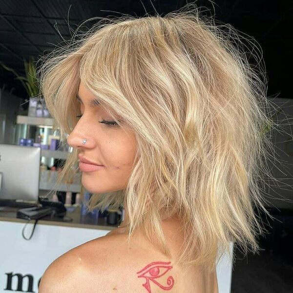 Short Hair with Root Shadow Platinum Blonde - a woman with an eye tattoo on her back shoulder