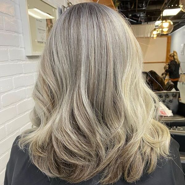 Silver Fox Platinum Blonde - a woman wearing a black salon cape