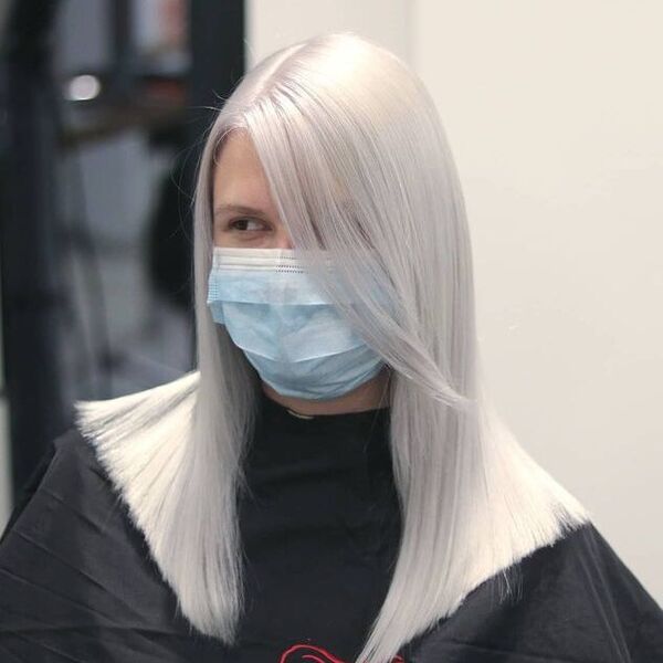Sleek Metallic White Blonde Hair - a woman wearing a black cape