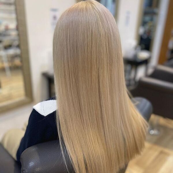 Straight and Long Ash Blonde - a woman sitting in a salon chair