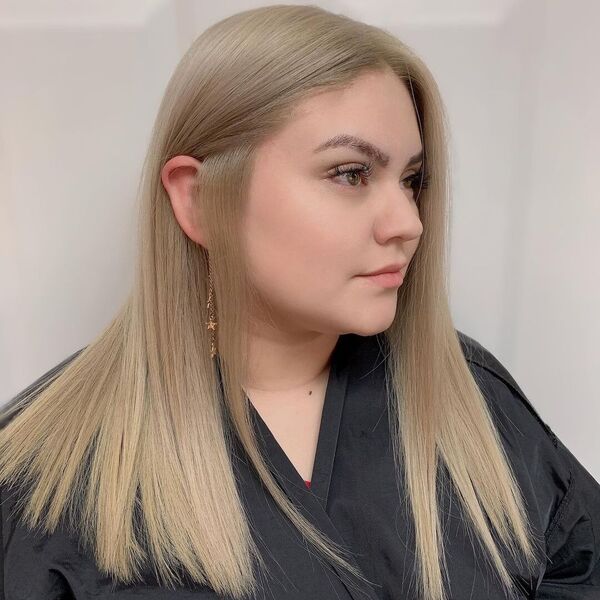 Straight Ash Creamy Blonde - a woman wearing a salon a black salon robe