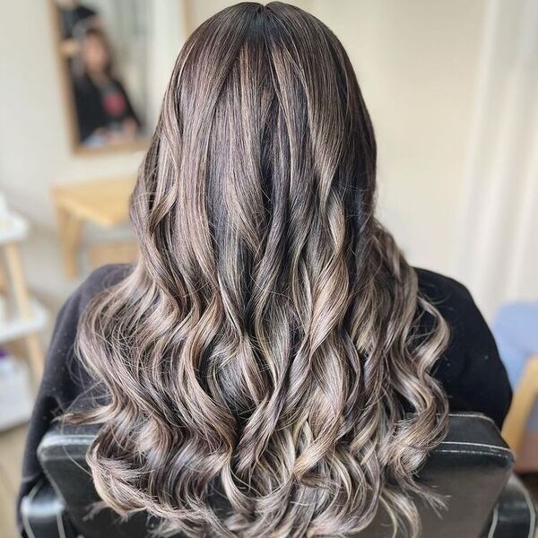 Textured Curl Light Ash Hair - a woman wearing a black towel and sitting in a salon chair