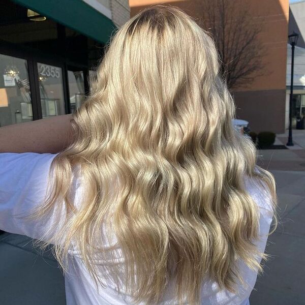 Warm Platinum Blonde - a woman wearing a white t shirt and is holding her hair