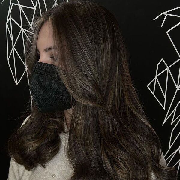 Wavy Cedar Balayage on Dark Hair - a woman wearing knitted blouse.