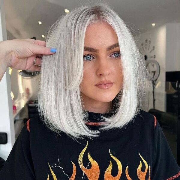 White Blonde Flipped Bob Haircut - a woman wearing a black printed shirt