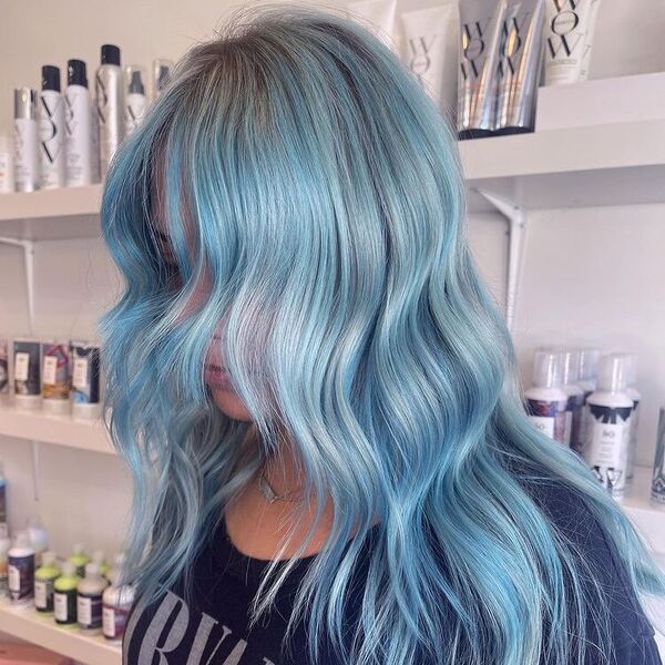 Winter Blues Blonde Balayage - a woman wearing a Nirvana shirt and in her back are salon supplies