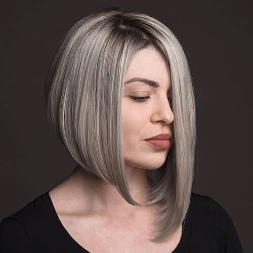 a woman wearing a black blouse has a long asymmetrical inverted bob haircut