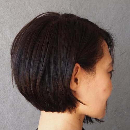 a woman wearing a black blouse has a short inverted bob hairstyle