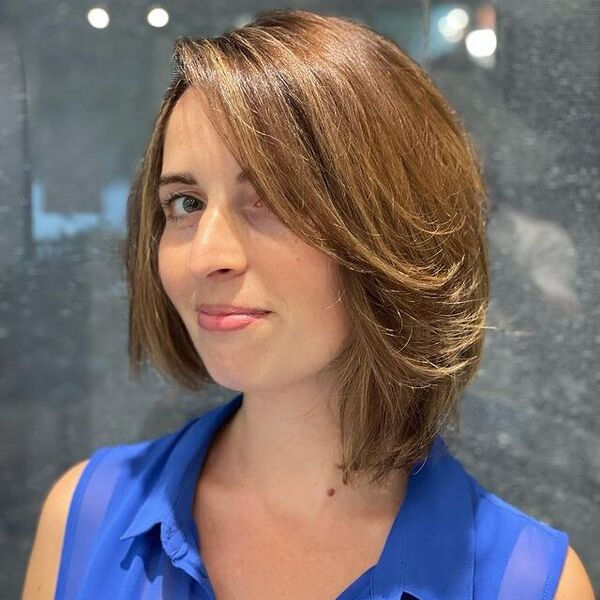 A woman wearing a blue sleeveless blouse