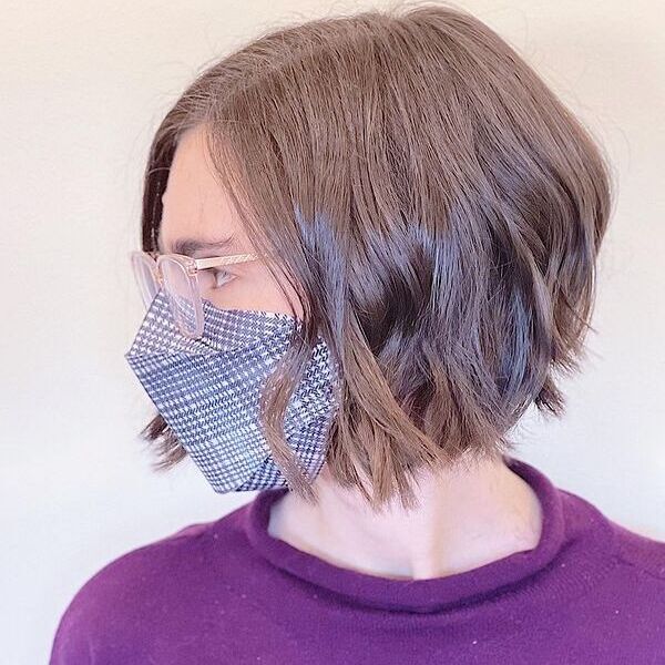 A woman wearing eyeglasses and a facemask